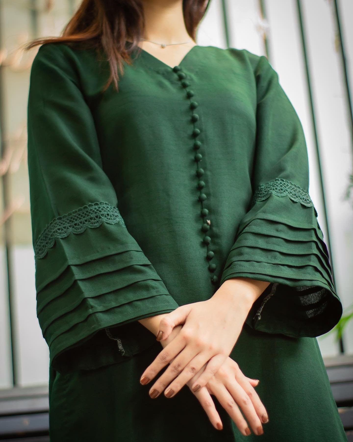 Close up on the details of embroidery on sleeves and buttons on the shirt.