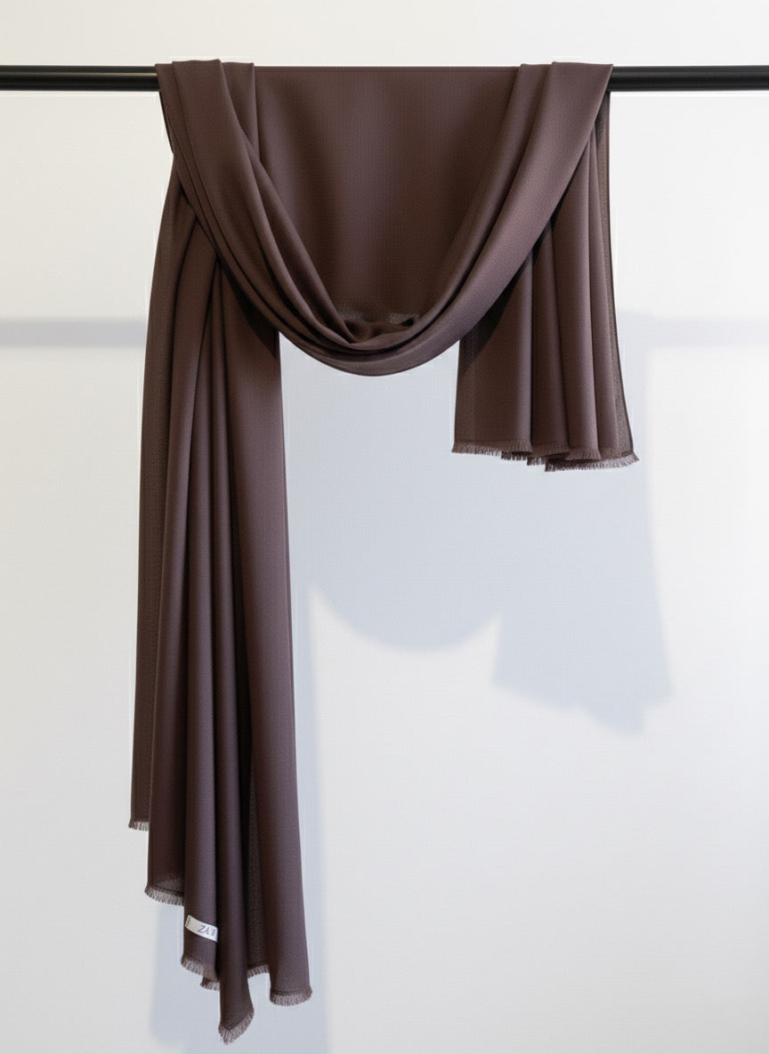 Dark Brown scarf draped over a black rod against a white background