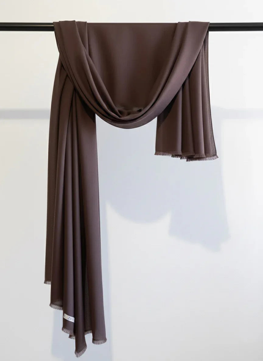 Dark Brown scarf draped over a black rod against a white background