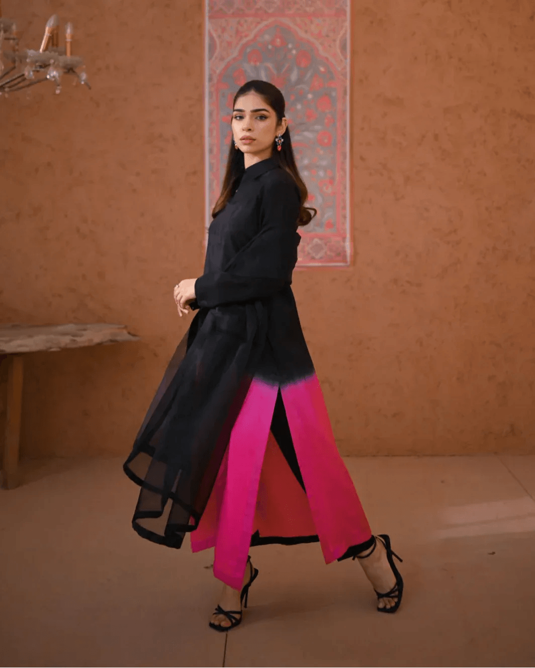 A woman wearing a three piece rawsilk dress with an ombre shirt and trousers, and an organza dupatta.