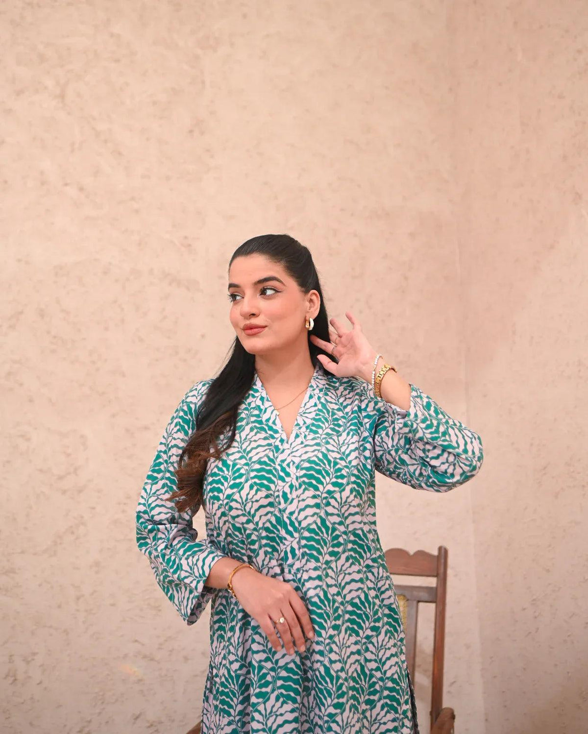 Women wearing a printed green and beige color two piece dress.
