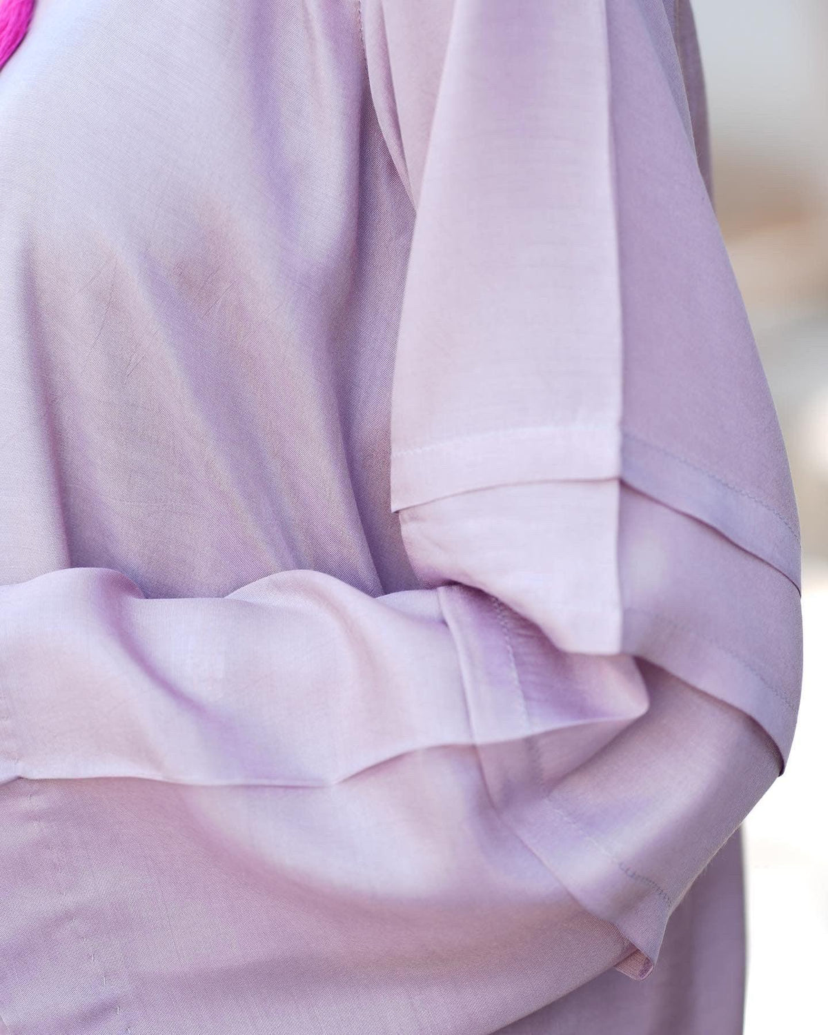 Close up on the details of sleeves of lilac dress.