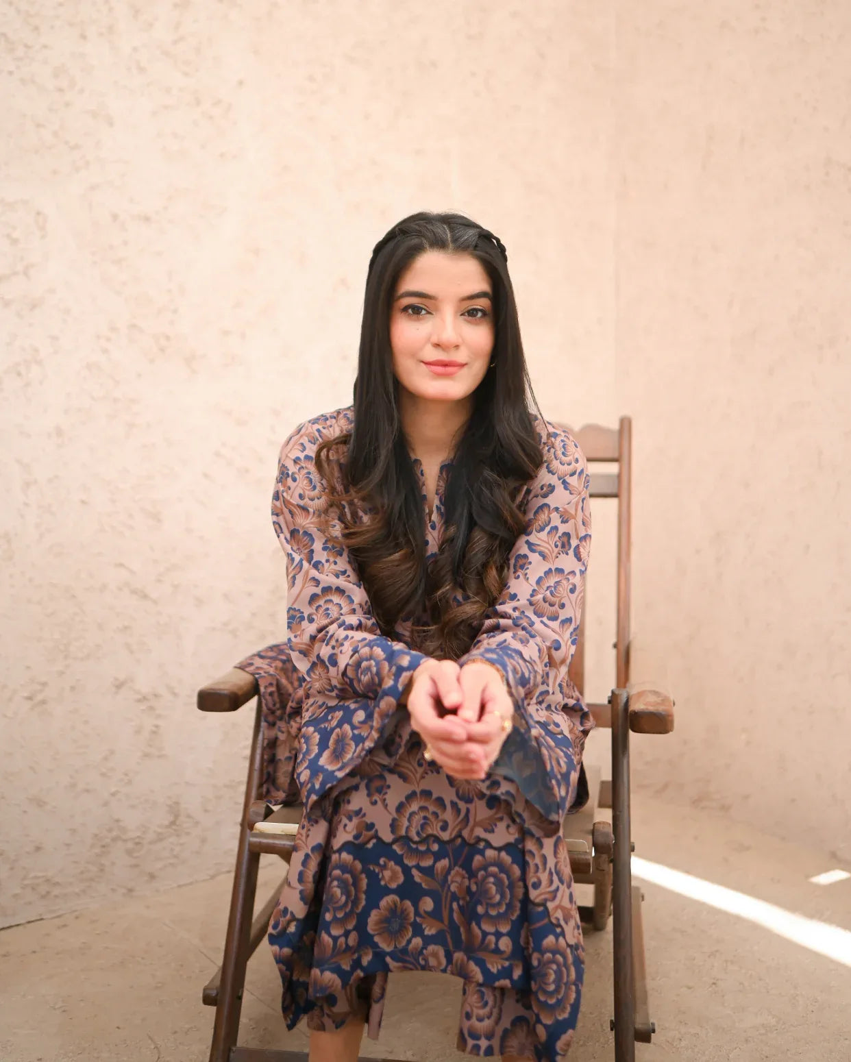A Women wearing a printed brown and navy blue color two piece dress. Print is floral.