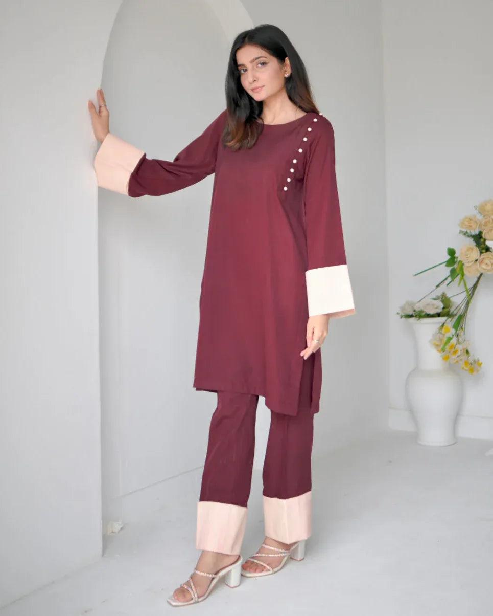 Women wearing a maroon two piece dress with phone color borders on sleeves and trousers.