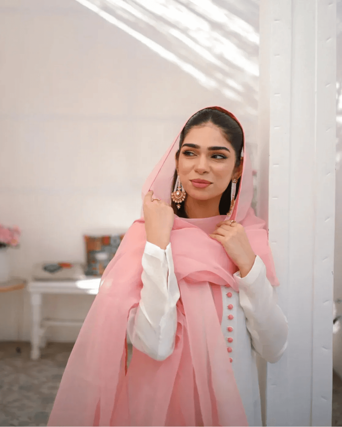 A woman wearing a three piece rawsilk dress with an ombre shirt and an organza dupatta in pink and white colors.