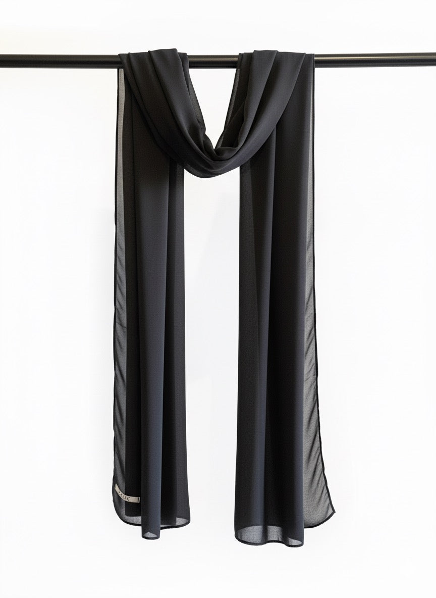 Black scarf draped over a black rod on a white background