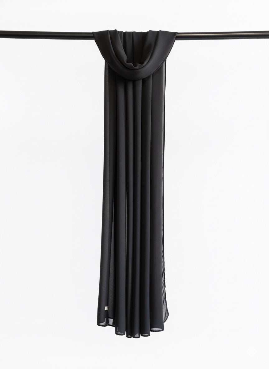 Black scarf draped over a black rod on a white background