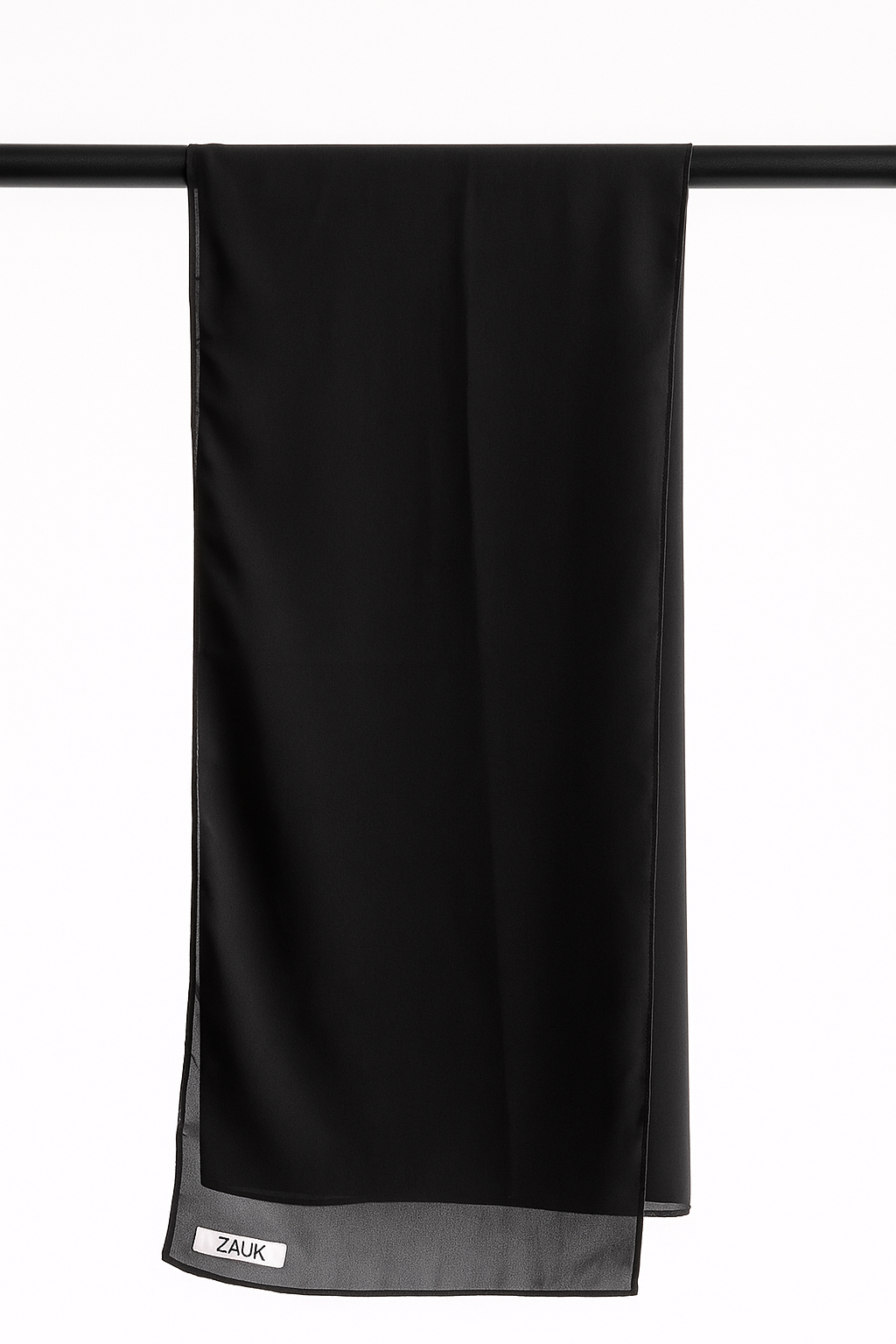Black scarf hanging on a rack against a white background