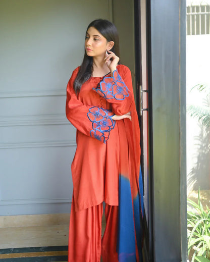 Women wearing a three piece orange dress which includes a Farshi Shalwar kameez with embroidery on sleeves,  and a two tone dyed chiffon dupatta.