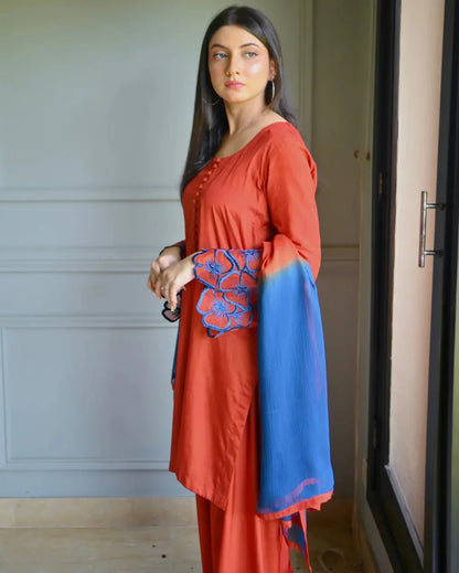 Women wearing a three piece orange dress which includes a Farshi Shalwar kameez with embroidery on sleeves and a two tone dyed chiffon dupatta.