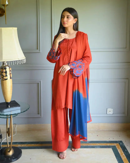 Women wearing a three piece orange dress which includes Farshi Shalwar kameez with embroidery on sleeves, and a two tone dyed chiffon dupatta.