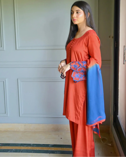Women wearing a three piece orange dress which includes Farshi Shalwar kameez with embroidery on sleeves and a two tone dyed chiffon dupatta.