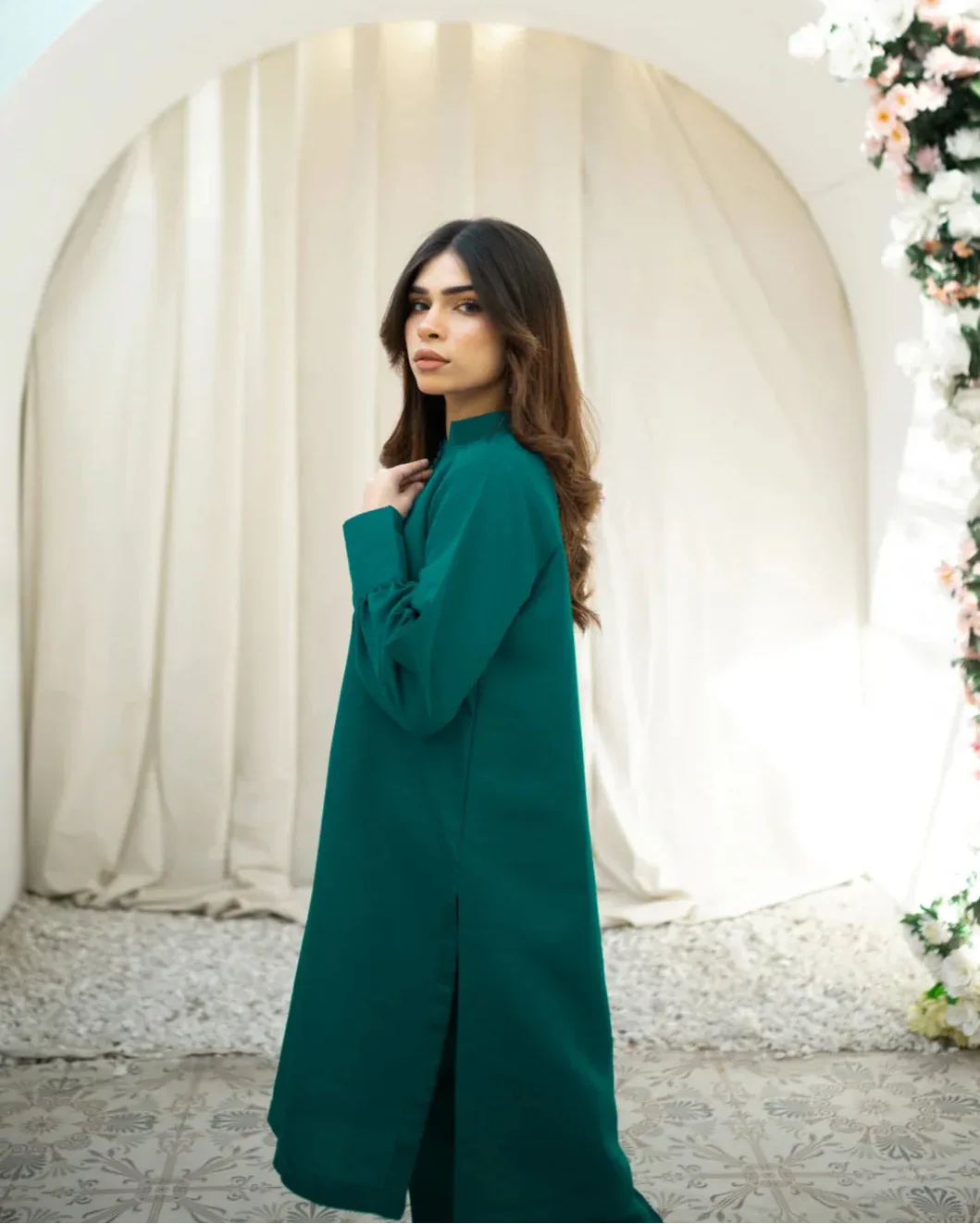A woman wearing a green indian rawsilk shirt.