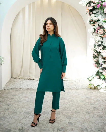 A woman wearing a green two-piece indian rawsilk dress consisting of a shirt and trousers.