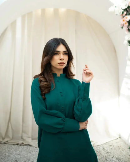 A woman wearing a green indian rawsilk shirt.