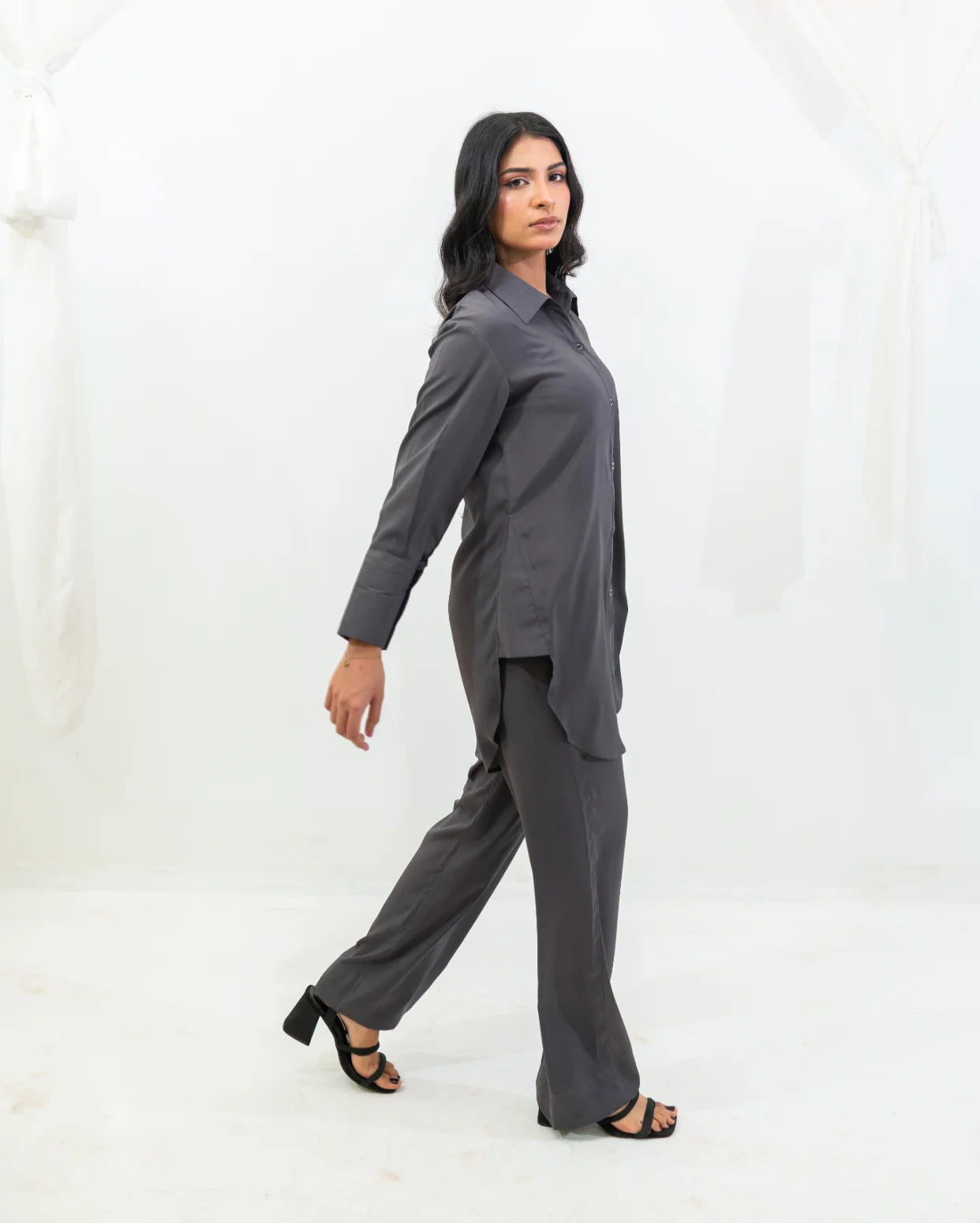 Woman wearing a charcoal gray outfit on a white background
