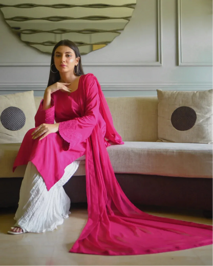 Women wearing a three piece pink color dress which includes a shirt with embroidery on sleeves, dhaka lehenga and a chiffon dupatta.