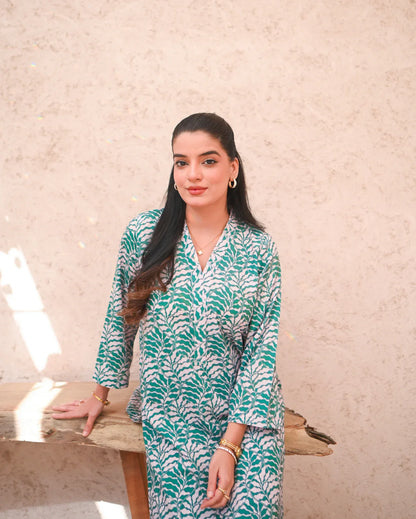 Women wearing a printed green and beige color two piece dress.