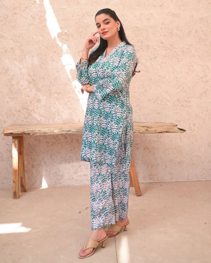 Women wearing a printed green and beige color two piece dress which includes a shirt and trouser.