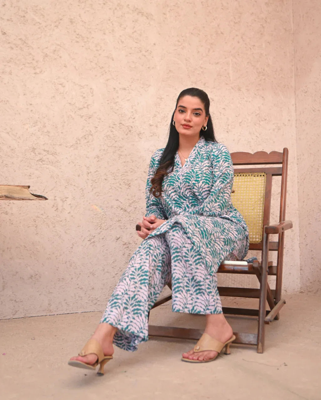 Women wearing a printed green and beige color two piece dress which includes a shirt and trouser.