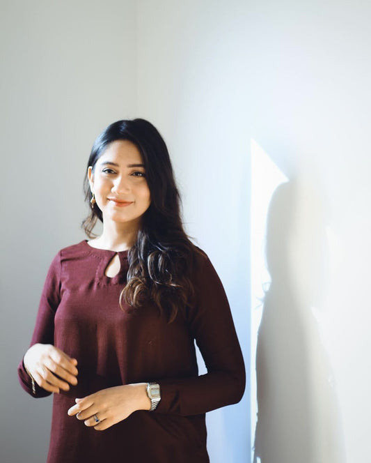 A women wearing a maroon two piece dress.
