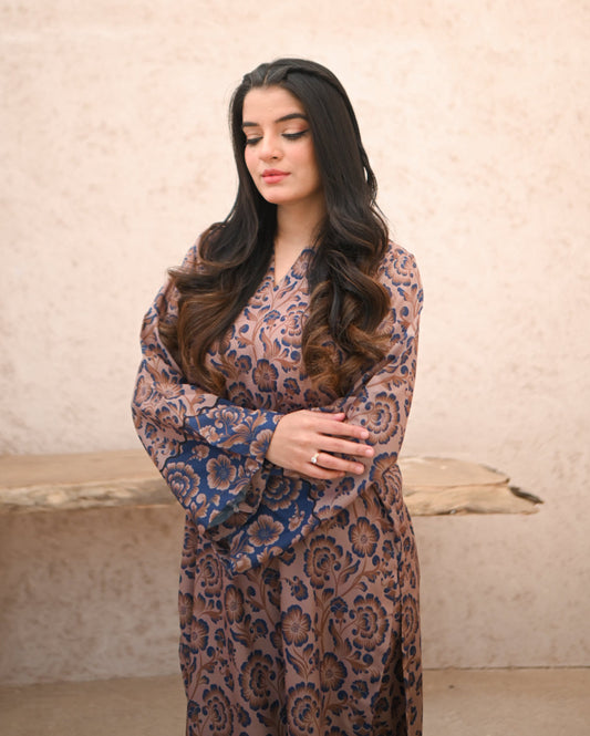 A Women wearing a printed brown and navy blue color two piece dress . Print is floral.