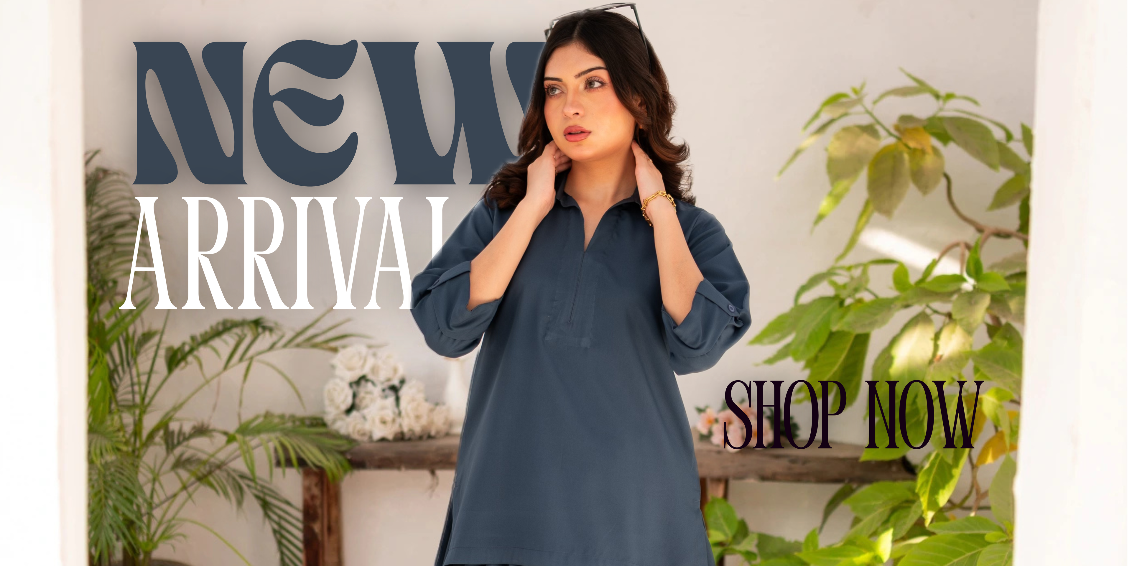 Woman wearing a steel blue dress with 'New Arrival' and 'Shop Now' text in a decorative setting.