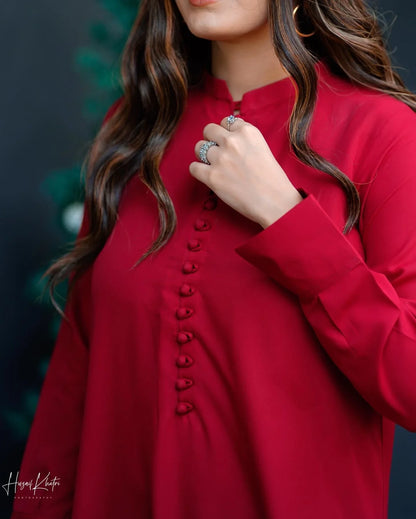 Close up on the cuffs of sleeves and loop buttons on red shirt.