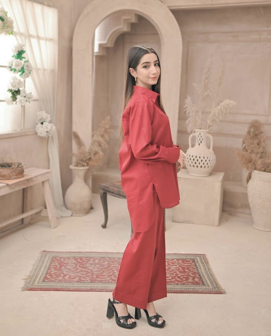 A woman in red dress stands confidently in a well-lit room, surrounded by neutral-colored walls and furniture.