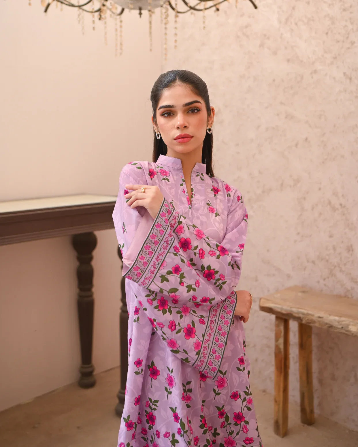 Woman wearing a pink floral printed dress in an indoor setting.