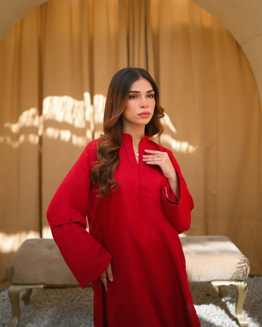 A Women wearing a Solid Red color two piece dress which includes a shirt and a culotte.