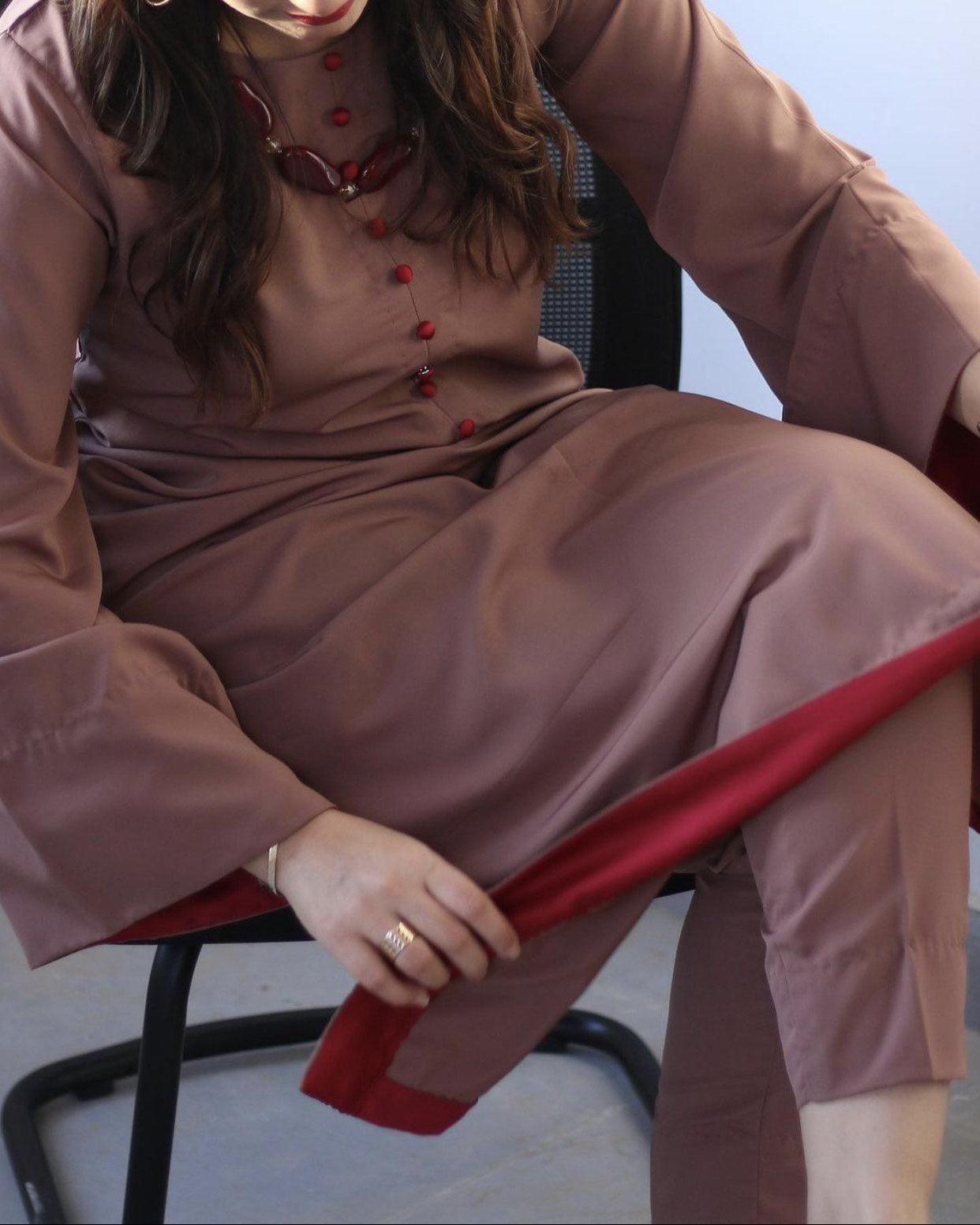 Close up on the details of the brown dress with red accents.