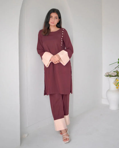 Women wearing a maroon two piece dress with phone color borders on sleeves and trousers.