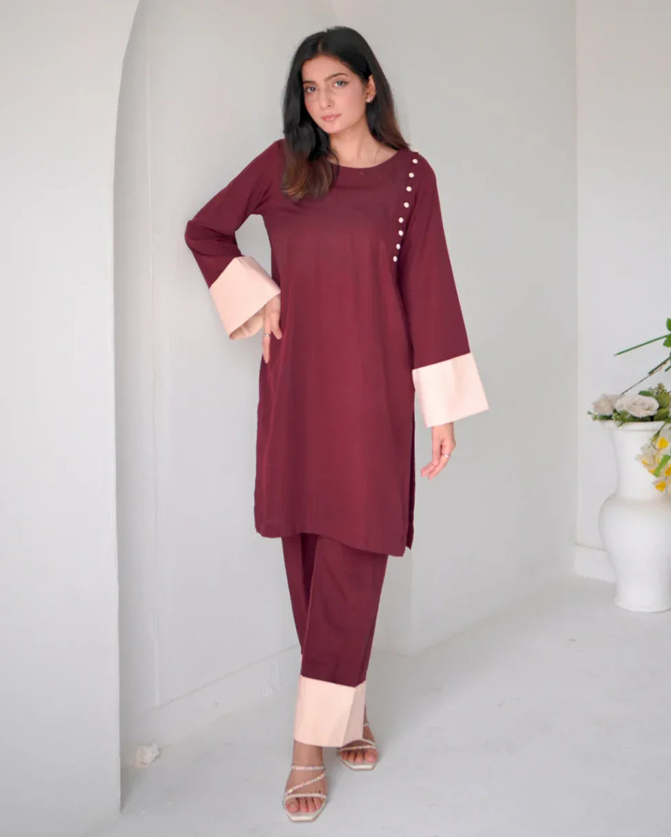 Women wearing a maroon two piece dress with phone color borders on sleeves and trousers.