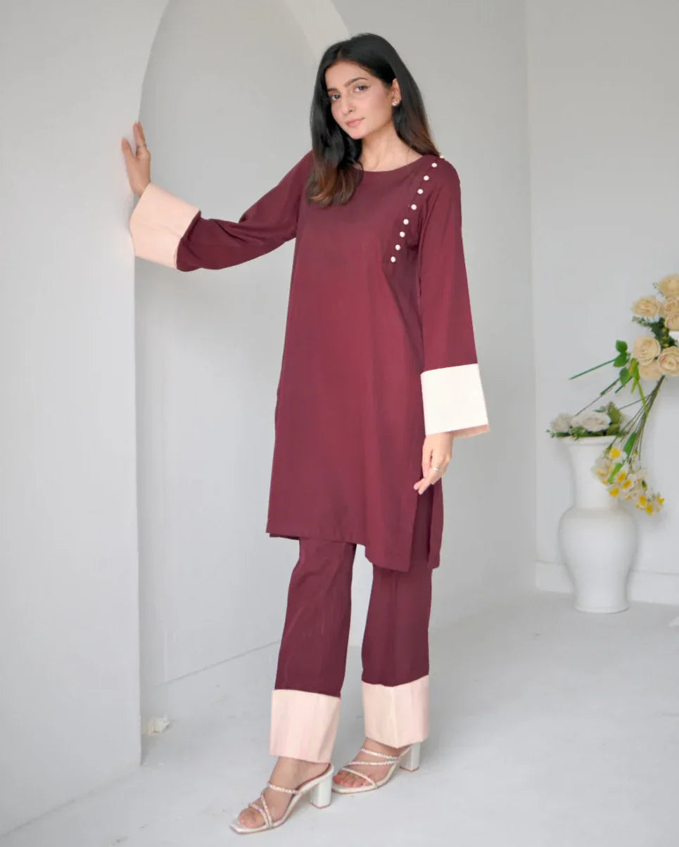 Women wearing a maroon two piece dress with phone color borders on sleeves and trousers.