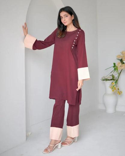 Women wearing a maroon two piece dress with phone color borders on sleeves and trousers.