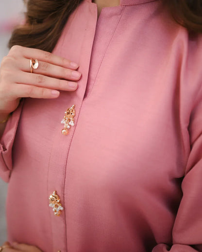 Close up of a women wearing a pink dress and highlighting the neck line.
